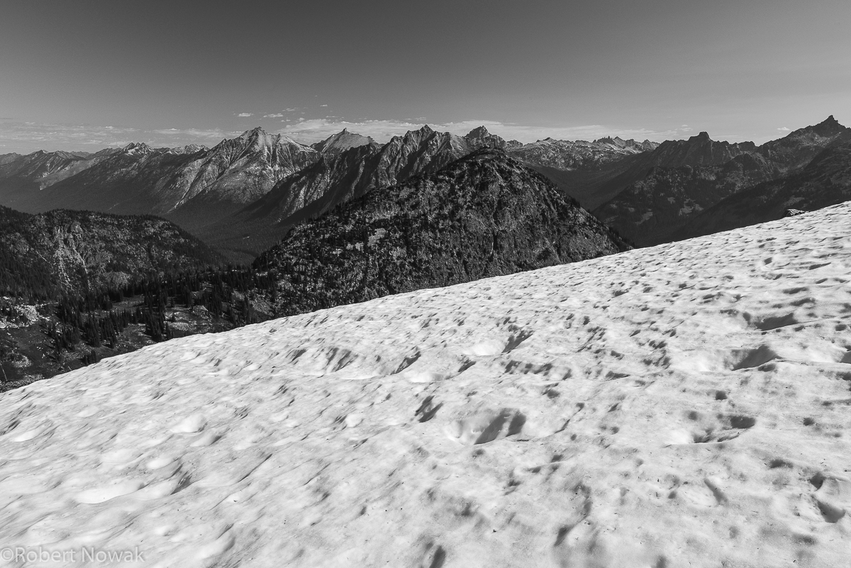 Looking north across a snowfield a the top of Maple Pass.